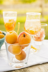 Ripe apricots in glass, drinks and sunny garden