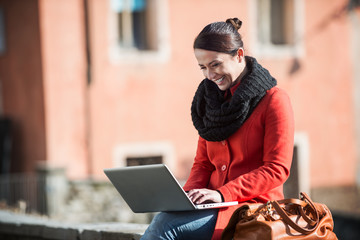 Woman using her laptop in the street