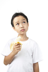 Boy eating banana and think