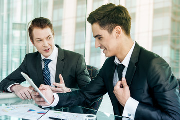 Two businessman using tablet in meeting