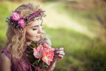 Beautiful blonde girl in a pink dress has got a bouquet