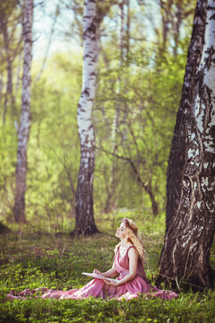 Girl in a fairy dress sitting under a tree