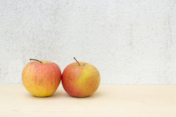 two apple still life on concrete wall and plywood background