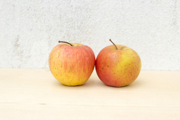 two apple still life on concrete wall and plywood background