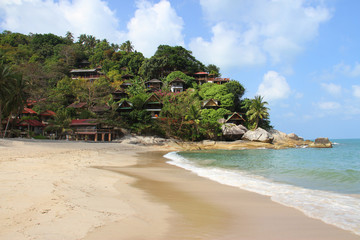beautiful tropical beach and bungalows on rocky hill