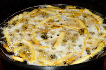 Potato is fried in the boiling oil in the market