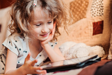 child girl playing with tablet at home