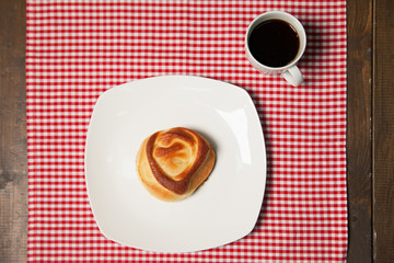 Coffee and sweet cupcake on checkered napkin
