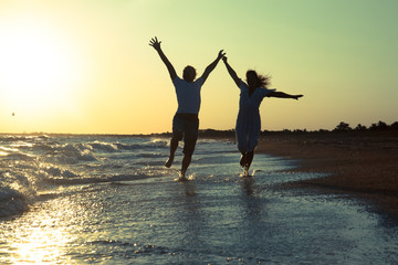 happy couple running on the beach