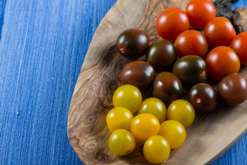 Colorful baby tomatoes on vibrant wooden background