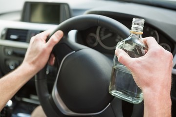 Close up of a man holding a bottle of vodka