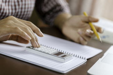 Image of woman using a calculator while working