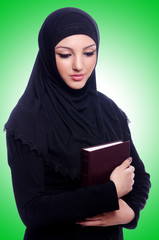Young muslim woman with book on white