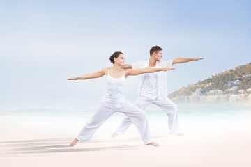 Fototapeta na wymiar Peaceful couple in white doing yoga together