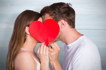 Composite image of side view of romantic couple holding heart