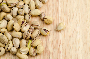 roasted and salted pistachios on wooden background