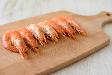 boiled shrimp arranged on a kitchen board - selective focus