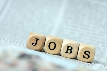 Holzwürfel mit dem Wort Jobs auf einer Zeitung