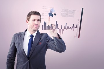 Composite image of focused businessman pointing with finger