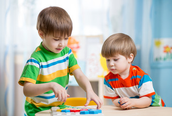 Fototapeta premium kids brothers play together at table