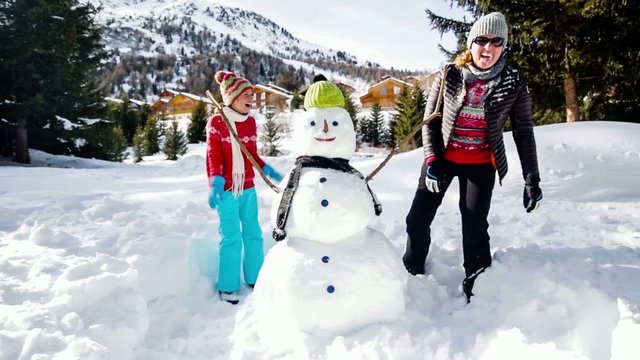 Winter fun, snowman and family in a snowball battle