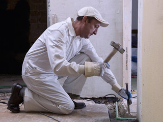 Naklejka na ściany i meble Worker using a hammer