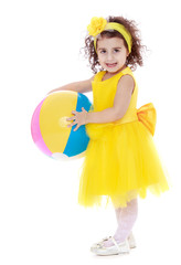 elegant, dark-haired little girl in a yellow dress and a ball in