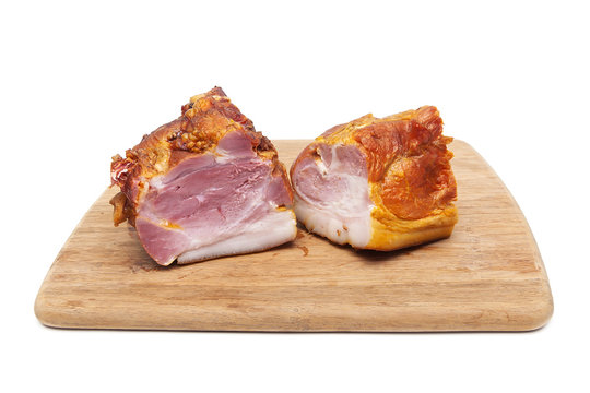 smoked pork neck on a wooden cutting board on white background
