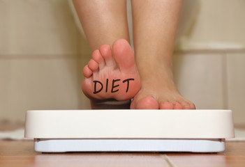 Feet on bathroom scale with hand drawn Diet text