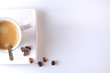 Cup with spoon and coffee beans on a table