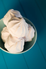 Delicate pink marshmallows lies in the blue plate