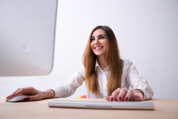 Portrait of a cheerful woman using computer in office