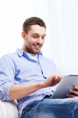 smiling man with tablet pc and cup at home