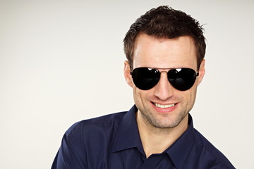 Obraz premium Handsome young man at shirt with sunglasses