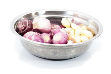 Peeled red shallots and garlic in bowl