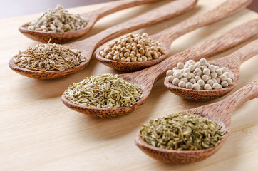 spoons of spices on cutting board