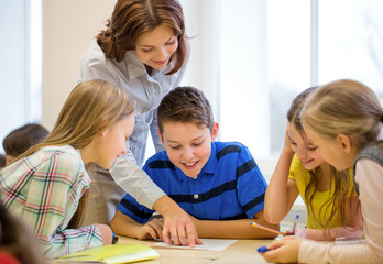 group of school kids writing test in classroom