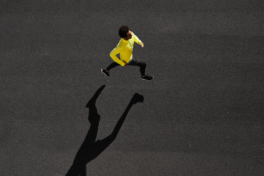 Top View Athlete Runner Training At Black Road In Yellow