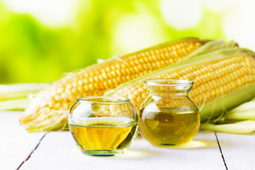 Corn oil and corn cobs on a garden table © efired