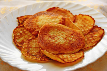 Small pancakes on a white plate. Wide pancake week