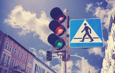 Retro filtered photo of traffic lights and pedestrian crossing sign, Szczecin, Poland.