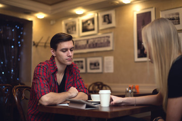 Two friends hipster man young woman are sitting in front of each