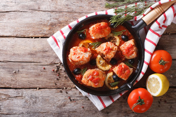 Fish in tomato sauce in a frying pan. horizontal top view