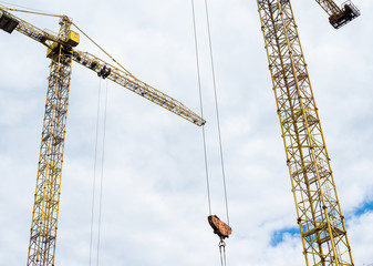 Tower cranes against the cloudy sky