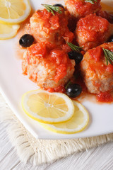 fish in tomato sauce with olives on the plate closeup vertical