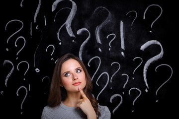 Young girl with question mark on a gray background