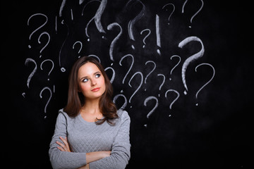 Young girl with question mark on a gray background