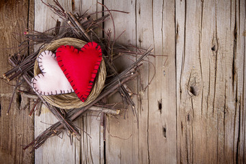 Two felt hearts in a wooden nest