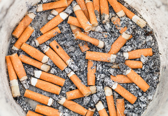 many cigarette ends in plastic pot