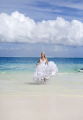 Fototapeta na wymiar beautiful woman runs on edge of sea on beach. Polynesia...